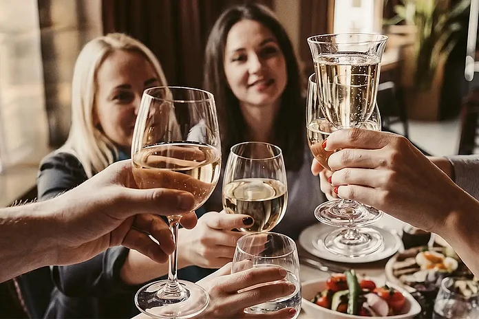 Personen mit Sekt in der Hand stossen an