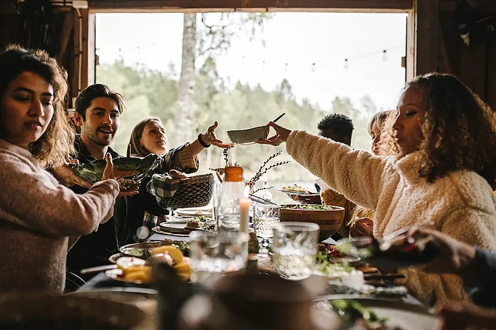 Bild mehrere Menschen am Tisch beim reden und Essen